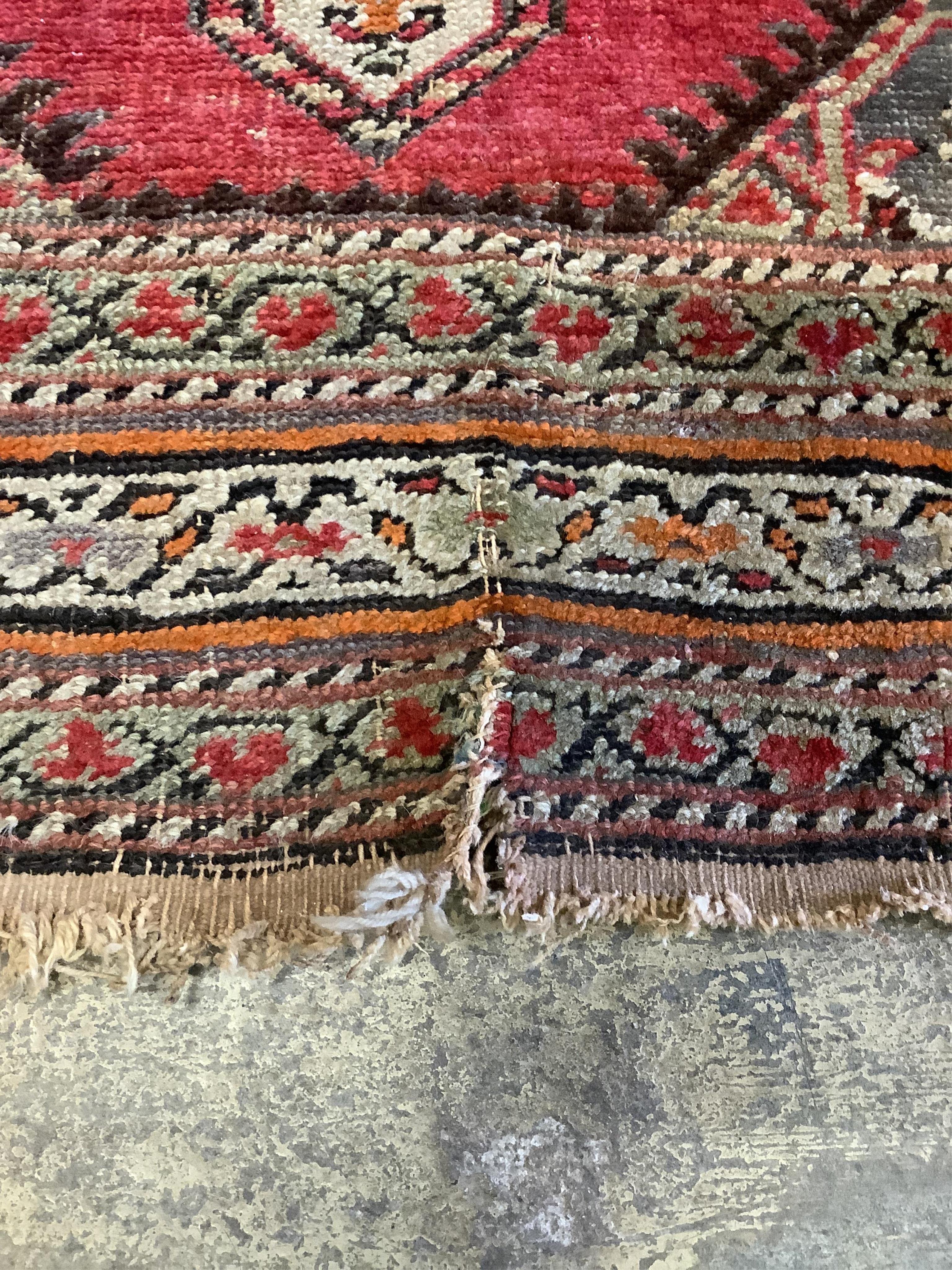 A Caucasian red ground runner, woven with a row of octagons, 416 x 106cm. Condition - fair